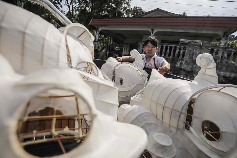 $!A Wan Seng Hang worker takes the lion head frames that has been applied with white bamboo paper from the woman's house using a pick-up truck. ADIB RAWI YAHYA/THESUN