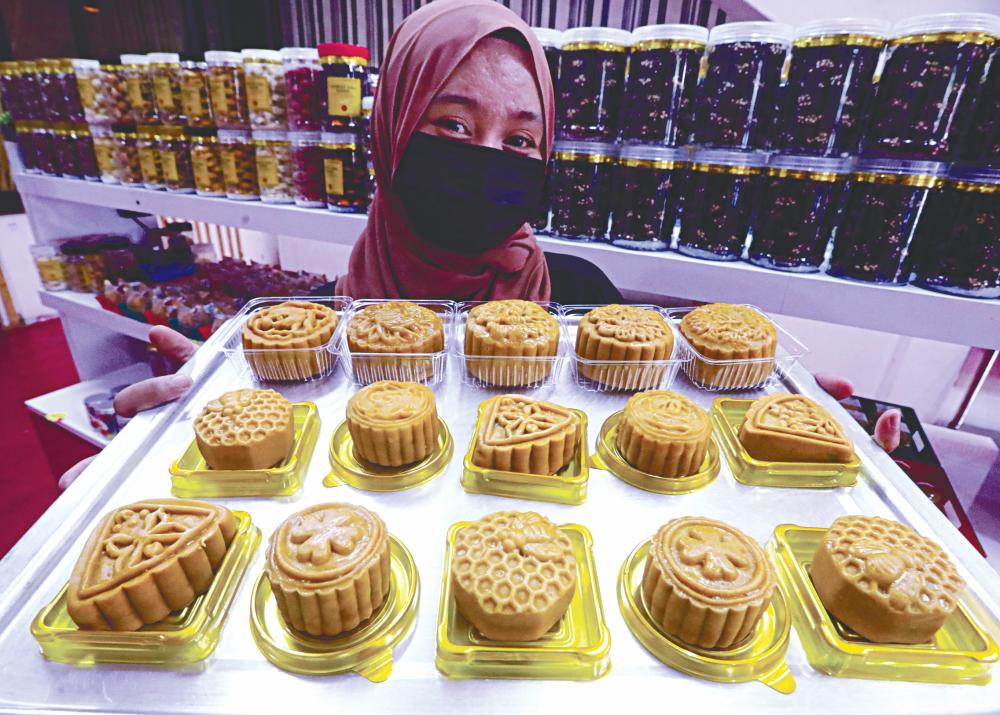 Farah Diba Bakery worker Shafrina Norhasni with some of the mooncakes that have been ordered by customers ahead of the festivities. – MASRY CHE ANI/THESUN