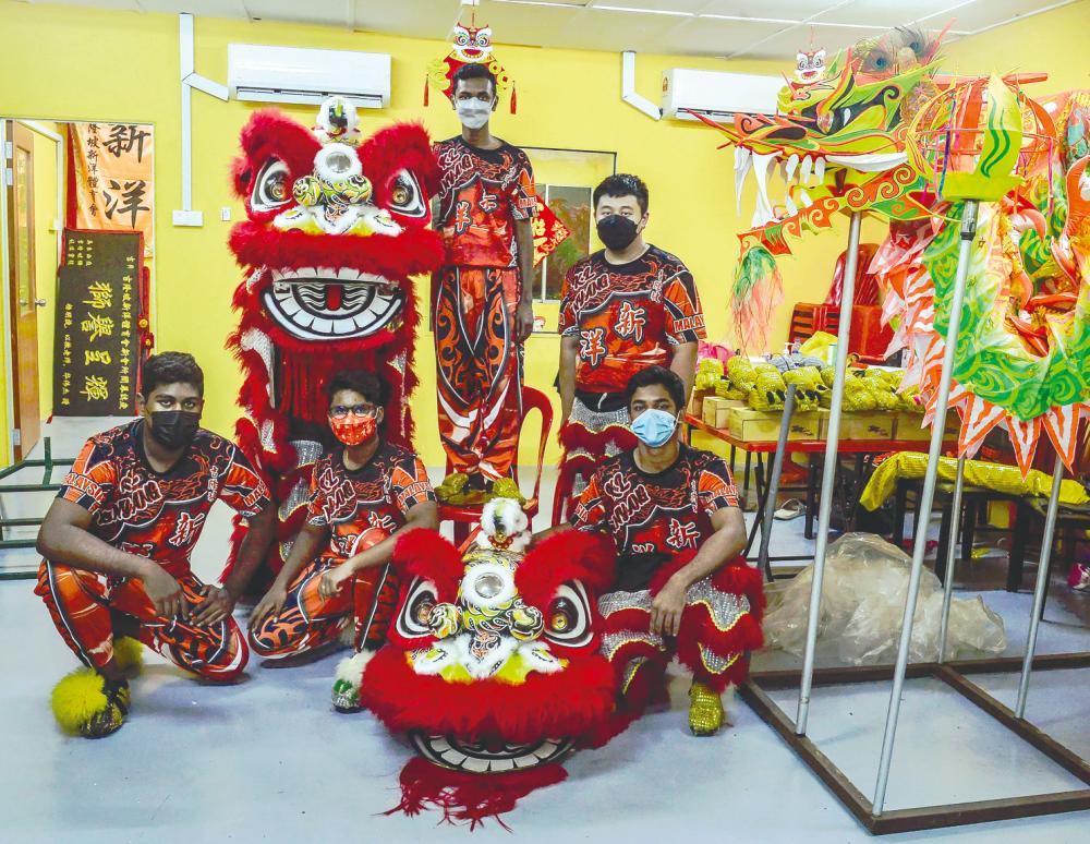 (From left) Praveen with troupe mates Darvin Palani, Dheena, Eason Tan and Azlan Shah Ibrahim Shah in their lion dance costumes. – ADIB RAWI YAHYA/THESUN