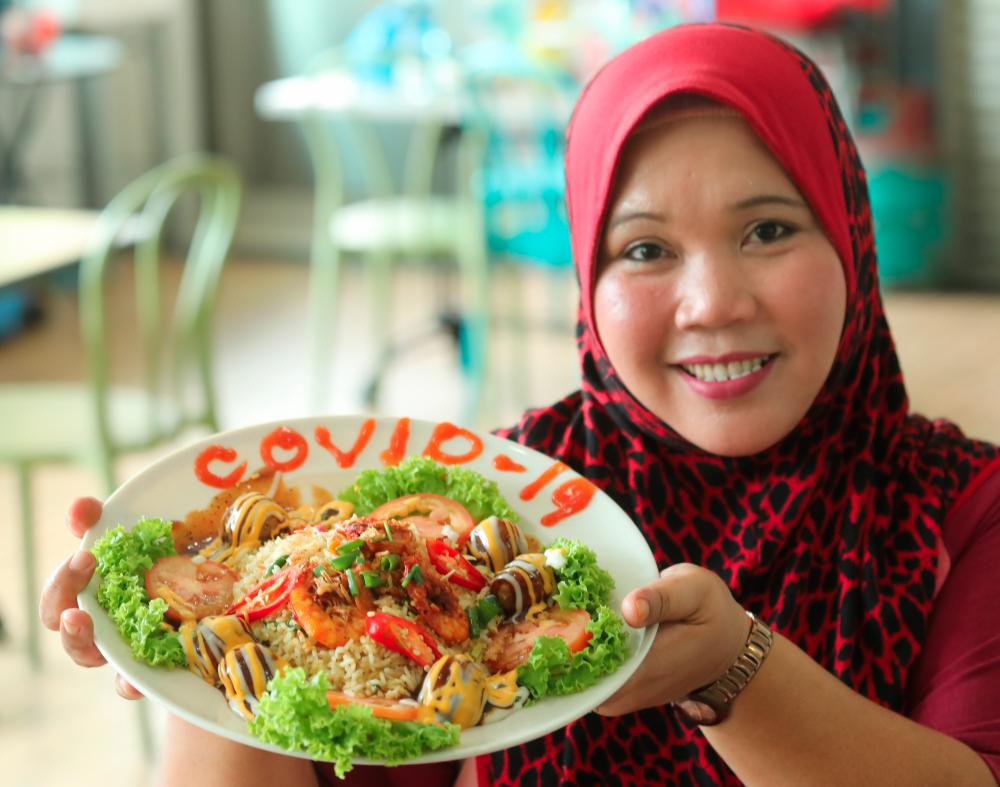 $!CREATIVE MARKETING ... Food stall operator Salmah Ibrahim’s fusion fried rice with 19 ingredients and named ‘Covid-19’ has become a hit among her customers at the Chowrasta Complex in George Town. – MASRY CHE ANI/THESUN