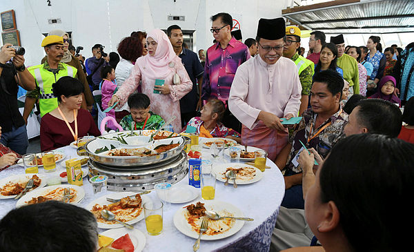 Sabah Chief Minister Datuk Seri Mohd Shafie Apdal hands over duit raya at the Aidilfitri open house organised by the state government at the Menara Tun Mustapa. — Bernama