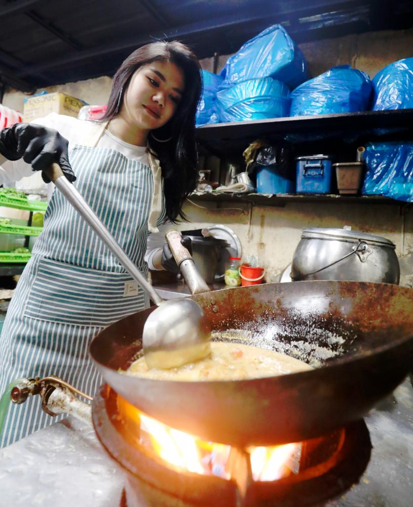 $!Nadiah working the wok at the restaurant. – MASRY CHE ANI/THESUN