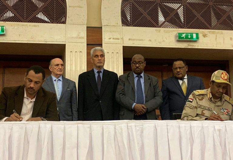 The deputy chief of Sudan’s ruling miliary council Mohamed Hamdan Dagalo (R) and protest leader Ahmed al-Rabie (L) initial an agreement before AU and Ethiopian mediators in Khartoum early on Wednesday. — AFP