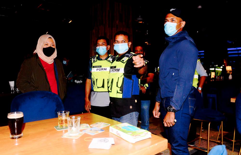 $!SPOT CHECK ... Johor police chief Datuk Ayob Khan Mydin Pitchay (third from left) with personnel from the district municipal council jointly conducting a raid on an entertainment outlet in Johor Baru yesterday.