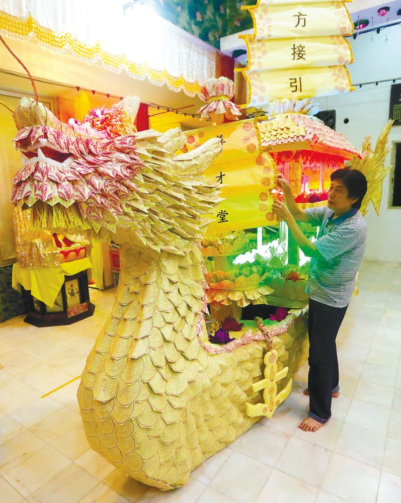 Loh putting the final touches on the paper ship at the temple in Air Itam, Penang yesterday. – MASRY CHE ANI/THESUN