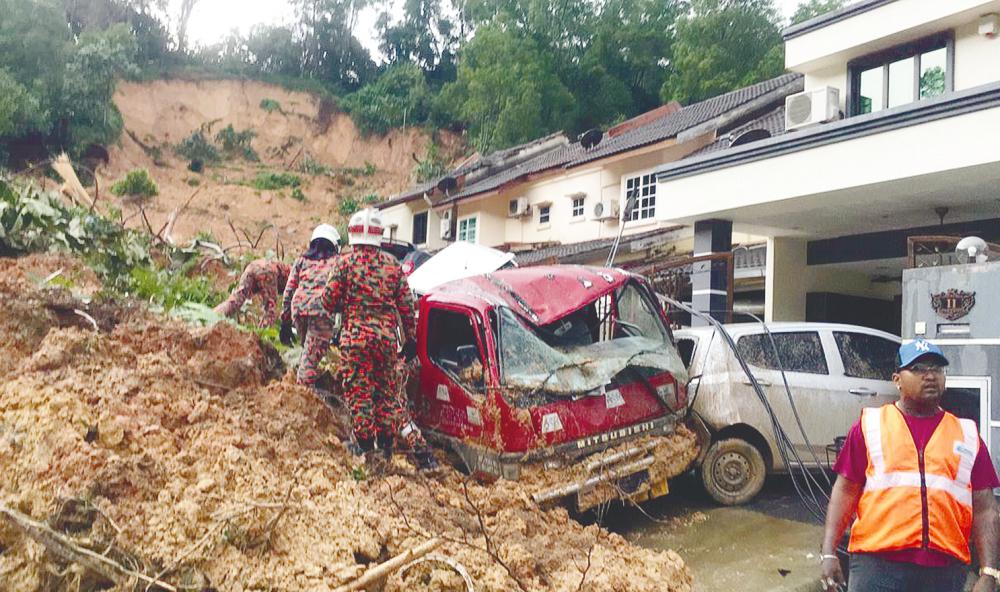 Fire and Rescue Department personnel at the landslide site in Taman Bukit Permai 2 in Ampang yesterday. – Picture courtesy of Fire and Rescue Department