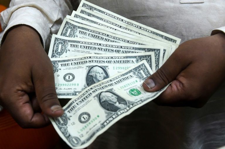 A Pakistani man counts US dollars at the currency exchange place in Lahore on May 16, 2019; meanwhile, gas stations in Lebanon are paid by customers in Lebanese pounds but must pay suppliers in US dollars . — AFP