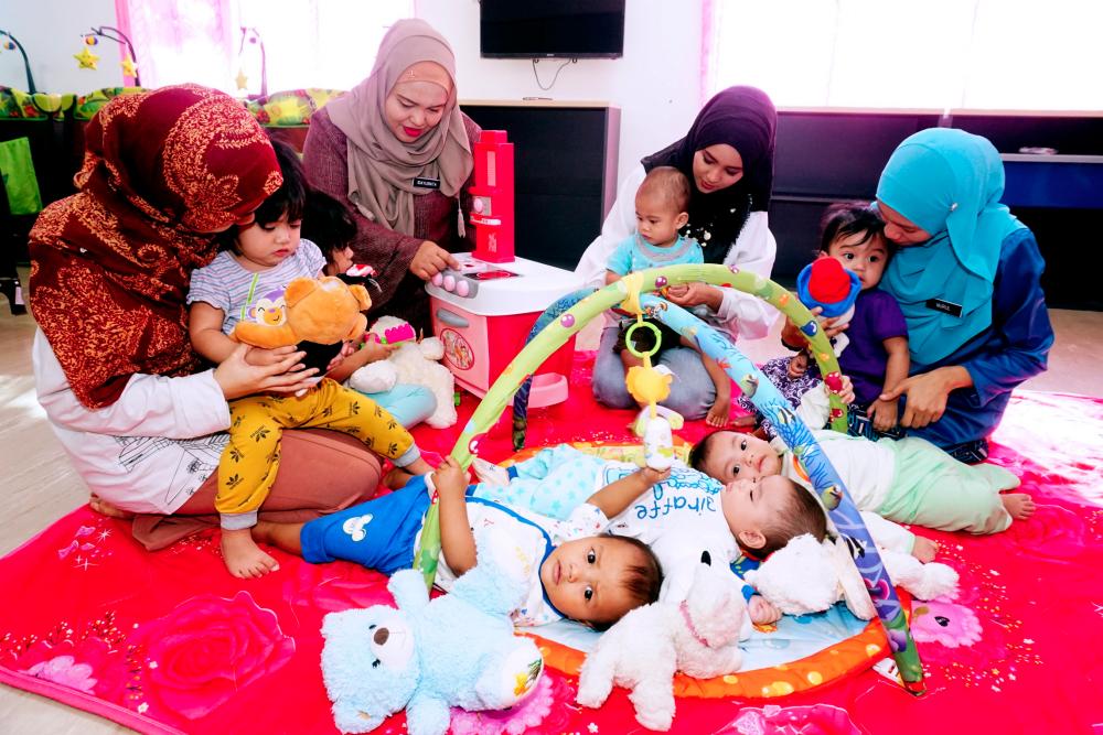Filepic of mothers and minders tending to children at a nursery located in the Muadzam Shah federal government administration complex in Alor Star, Kedah.