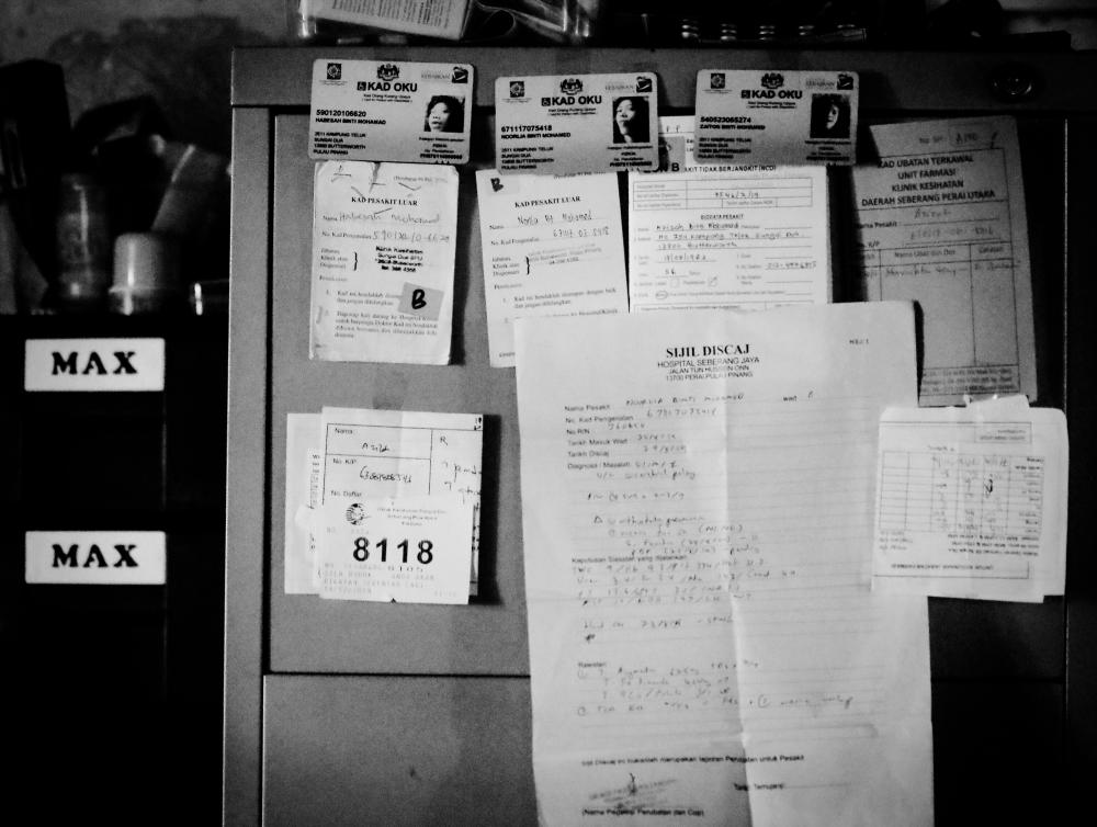 $!OKU identification card and hospital appointment letters and booklet belongings to her sisters were display at one of the cupboard in their house.