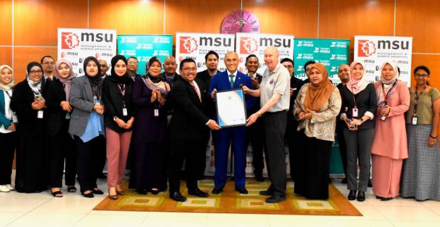 MSU president Professor Dr Mohd Shukri (centre) witnessed the presentation of the APIEM certificate by president Professor Hind (5th from right) to SHCA dean Azizul Jamaludin.