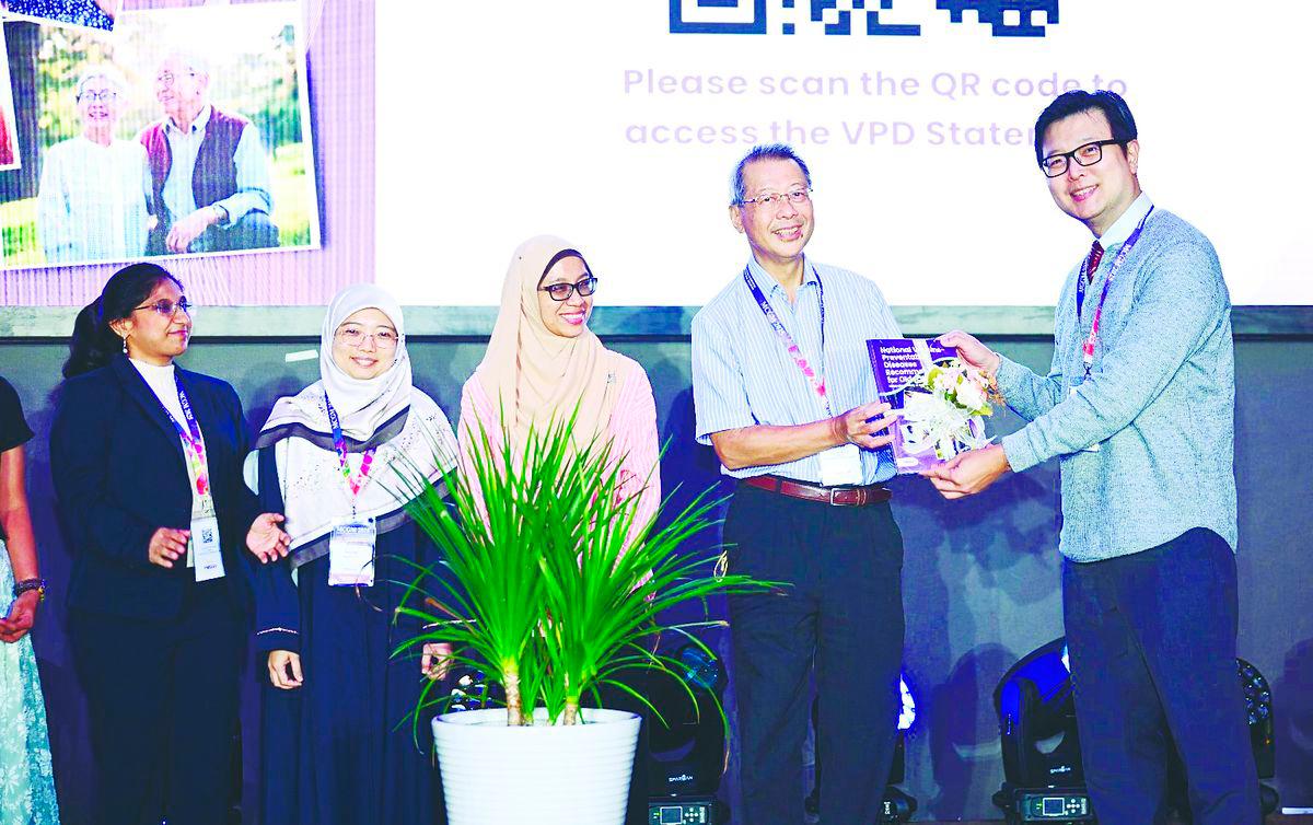 Public health milestone... Kejal (left) looks on as MSGM president Dr Alan Ch’ng (right) receives a copy of the booklet from Prof Dr Philip Poi Jun Hua, a veteran professor of geriatrics in Malaysia and a pioneer of MSGM. With them are Assoc Prof Dr Hakimah Sallehuddin (2nd left) and Dr Wan Mazlina Wan Mustapa.