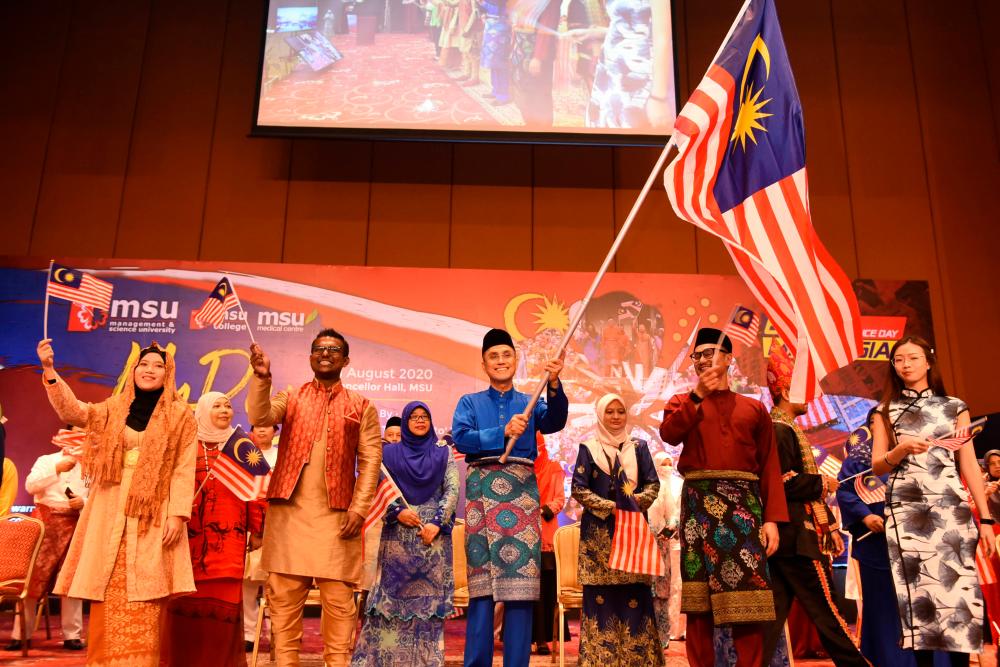 Mohd Shukri (centre) waving the Malaysian flag at the MSU My Day event that was held at the MSU Chancellor Hall at the main campus in Shah Alam