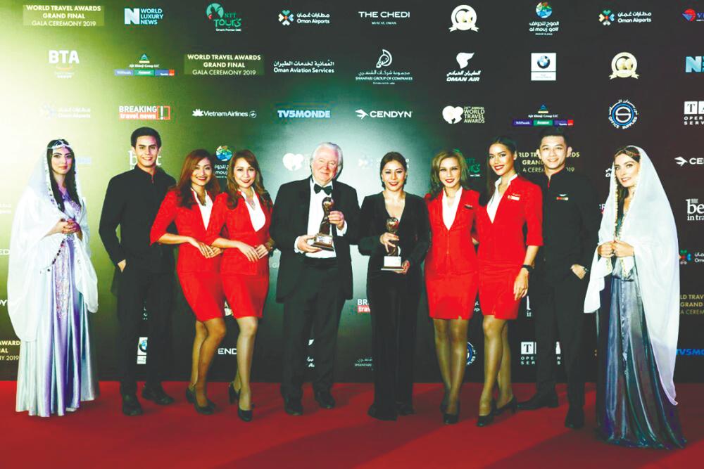 Suhaila (middle) accepting the World’s Leading Low-Cost Airline and World’s Leading Low-Cost Airline Cabin Crew awards together with Cooke (centre, left), flanked by AirAsia cabin crew.