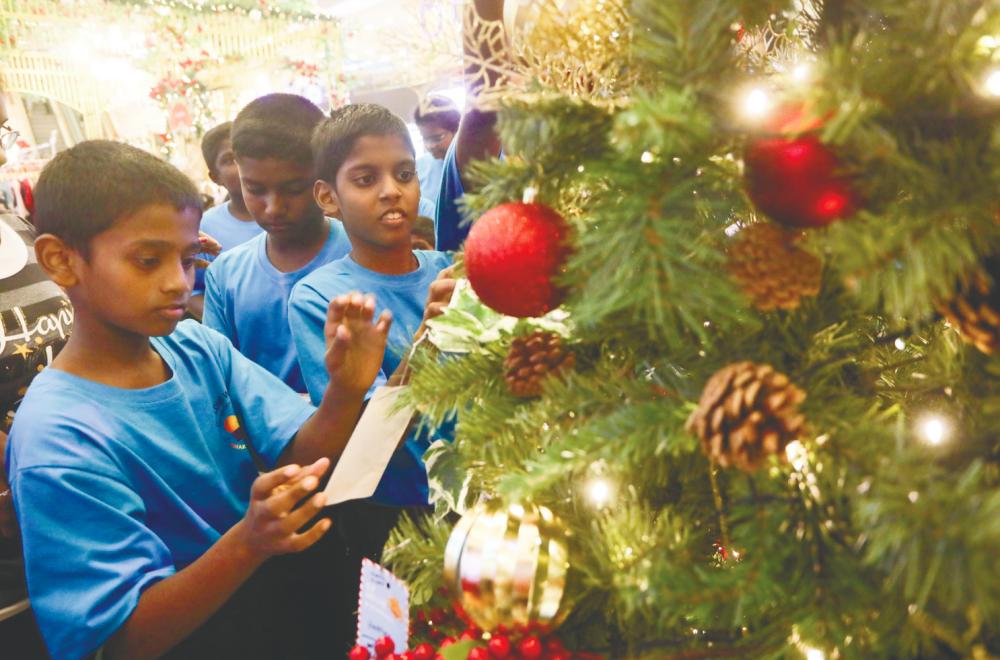 Children from the orphanage hanging their wishing cards on the Wishing Tree.