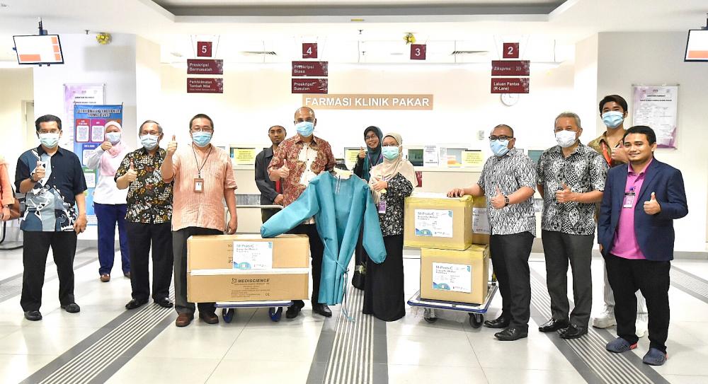 Mohd Shukri (fifth from left) presenting the PPE to a representative of Hospital Shah Alam.