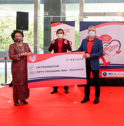 Aranols (right) presenting the mock cheque to UN Foundation chairman Toh Puan Dr Aishah Ong (left) and UN Foundation senior executive Fakhrulrazi Muhthar (middle).