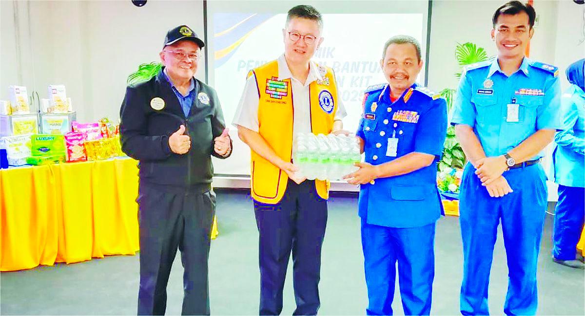 Tan presenting a carton of drinking water to Rohaizat. – P. CHANDRA SAGARAN/THESUN
