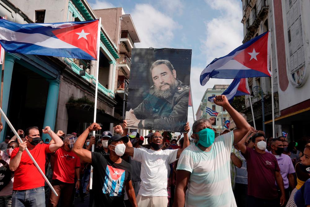 Government supporters hold a photograph of Cuba’s late President Fidel Castro during protests against and in support of the government, in Havana, Cuba July 11, 2021. — Reuters
