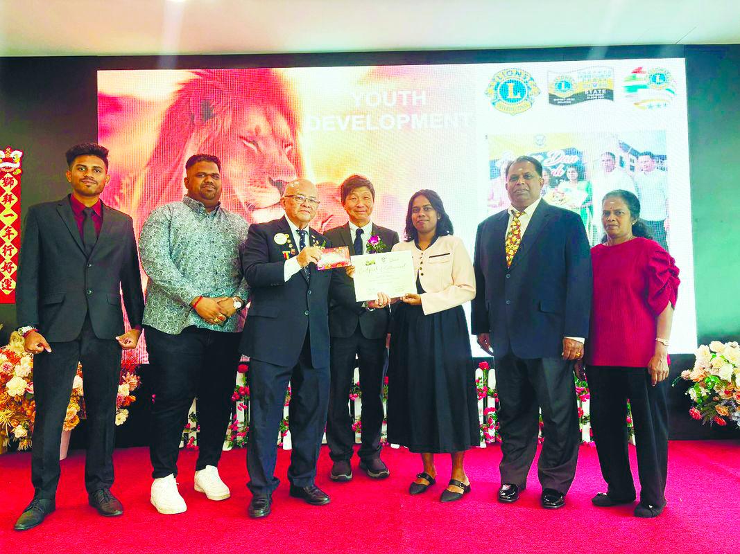 Ng presenting the bursary and certificate to Sarmili for her STPM achievement.