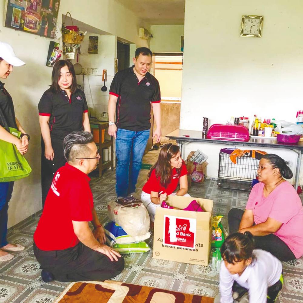 $!Tengku Zatashah (centre) chatting with a recipient of the aid given out by Kechara. – Courtesy of Tengku Zatashah