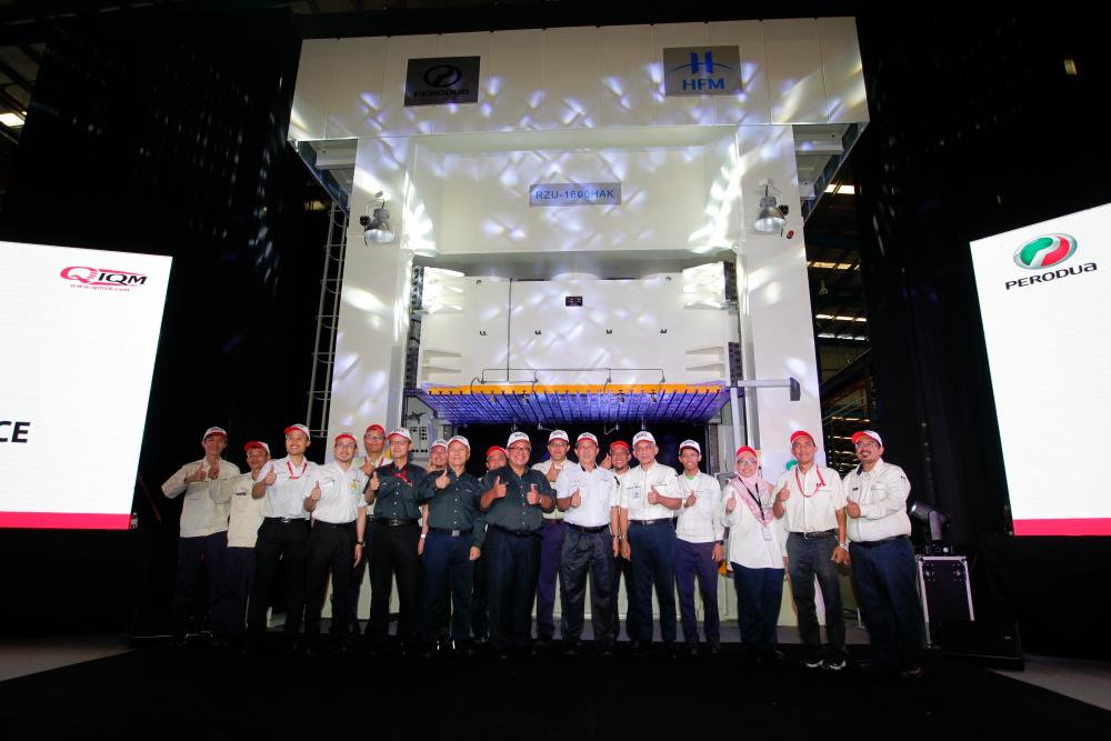 Zainal Abidin (10th from left), Perodua vice-chairman Datuk Shigeharu Toda (6th left), Perodua Auto Corporation Sdn Bhd president Masanori Takahashi (8th from left) and vice-president Datuk Ahmad Suhaimi Hashim (14th from left) and IQM Sdn Bhd managing director Mohd Fitri Md Aris (12th from left) pose with the Perodua and IQM teams involved in the project in front of the new 1,600-metric tonne hydraulic press stamping machine that was launched earlier today at IQM’s Tanjung Malim facility.