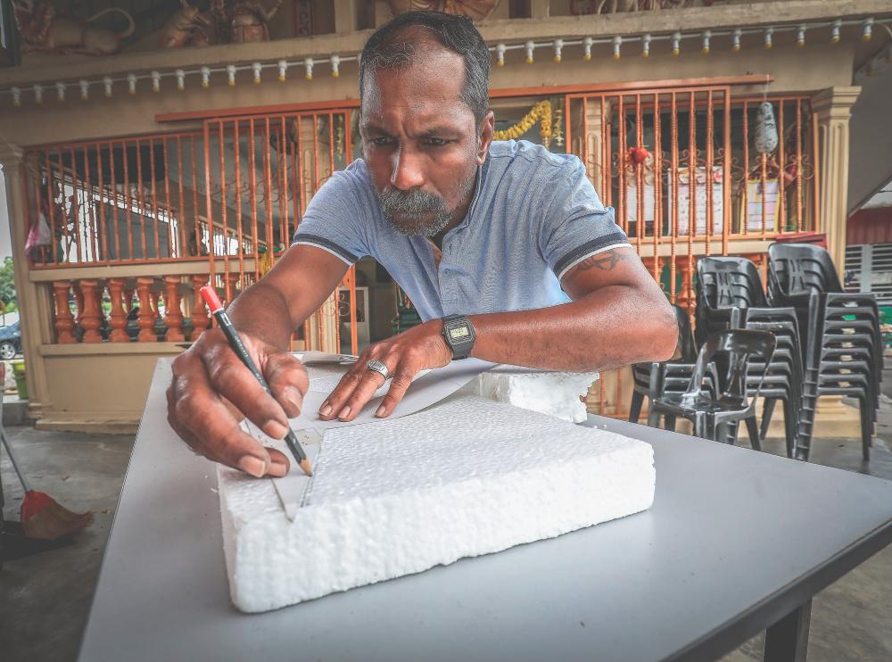 M. Mohana Sundaram sketching his design on polystyrene for his kavadi making.