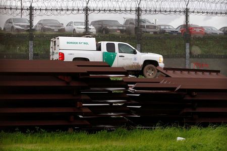 A US border patrol vehicle drives past metal sections to be used to fix the border fence between Mexico and the US, as seen from Tijuana, Mexico, on Feb 14, 2019. — Reuters