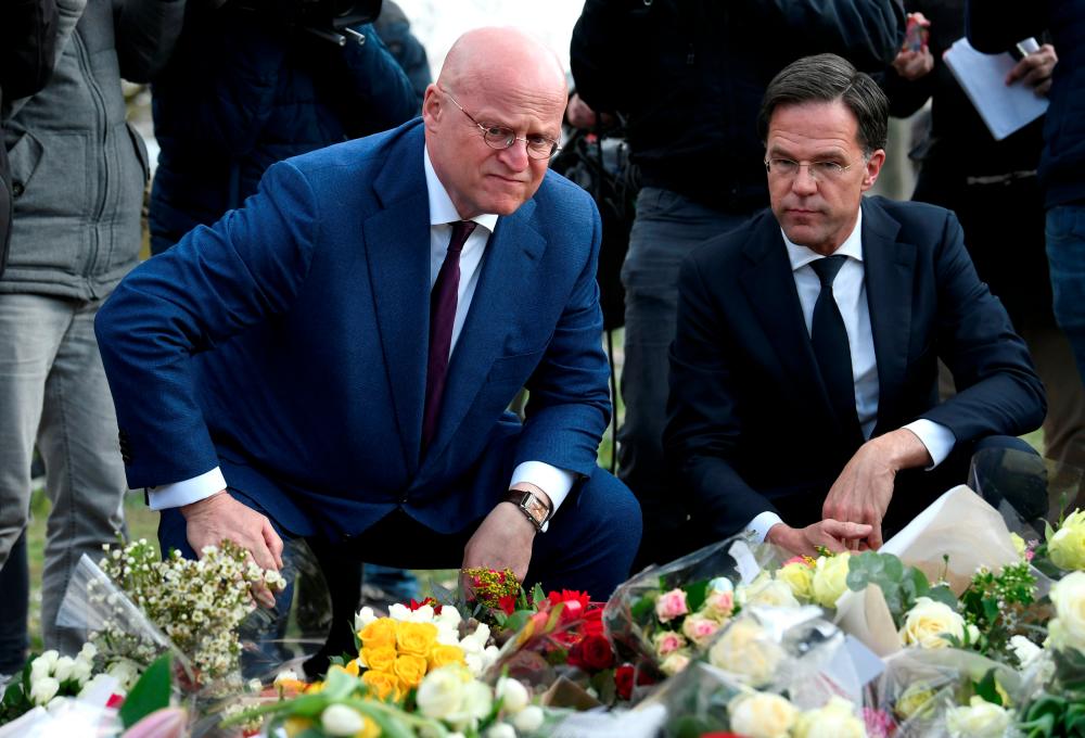 Dutch Prime Minister Mark Rutte and Minister of Justice and Security Ferdinand Grapperhaus place flowers at a makeshift memorial at the site of a tram shooting in Utrecht, Netherlands March 19, 2019. — Reuters