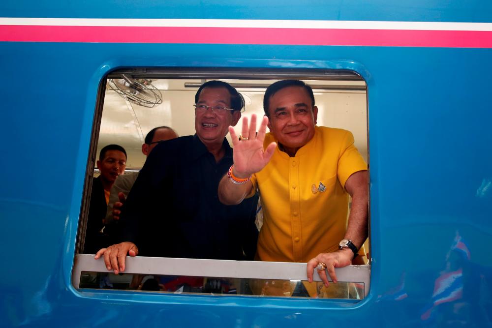 Thailand Prime Minister Prayuth Chan-ocha and his Cambodian counterpart Hun Sen ride a train during a ceremony to re-establish a rail link between the two countries at the friendship bridge at the Ban Nong Ian-Stung Bot border April 22, 2019. — Reuters
