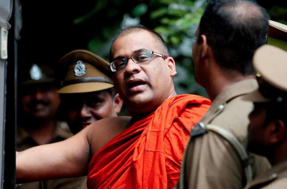 Galagoda Aththe Gnanasara Thero, head of Buddhist group Bodu Bala Sena (BBS), walks towards a prison bus while accompanied by prison officers after he was sentenced by a court in Sri Lanka on June 14, 2018. — Reuters