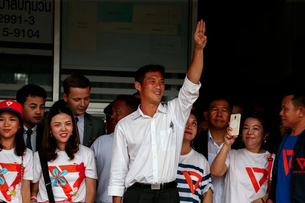 Thanathorn Juangroongruangkit, leader of the Future Forward Party flashes a three-finger salute to his supporters as he leaves a police station after hearing a sedition complaint filed by the army, in Bangkok, Thailand on April 6, 2019. — Reuters