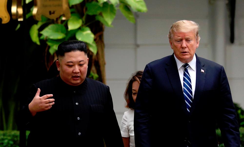 North Korea’s leader Kim Jong Un and U.S. President Donald Trump talk in the garden of the Metropole hotel during the second North Korea-U.S. summit in Hanoi, Vietnam February 28, 2019. — AFP
