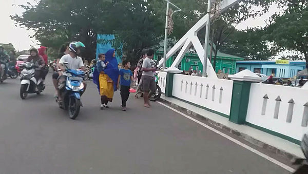 People look over a bridge as they flee after an earthquake in Ternate, North Maluku, Indonesia July 14, 2019 — video grab from Egon Enviro Batu Bacan social media