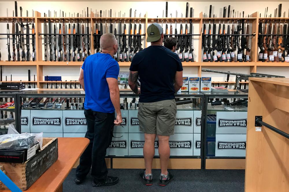 People look at firearms and accessories on display at Gun City gunshop in Christchurch, New Zealand, March 19, 2019. — Reuters