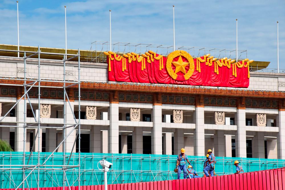 Men work on setting up a giant installation at the Tiananmen Square ahead of China’s 70th founding anniversary in Beijing, China August 14, 2019. — AFP