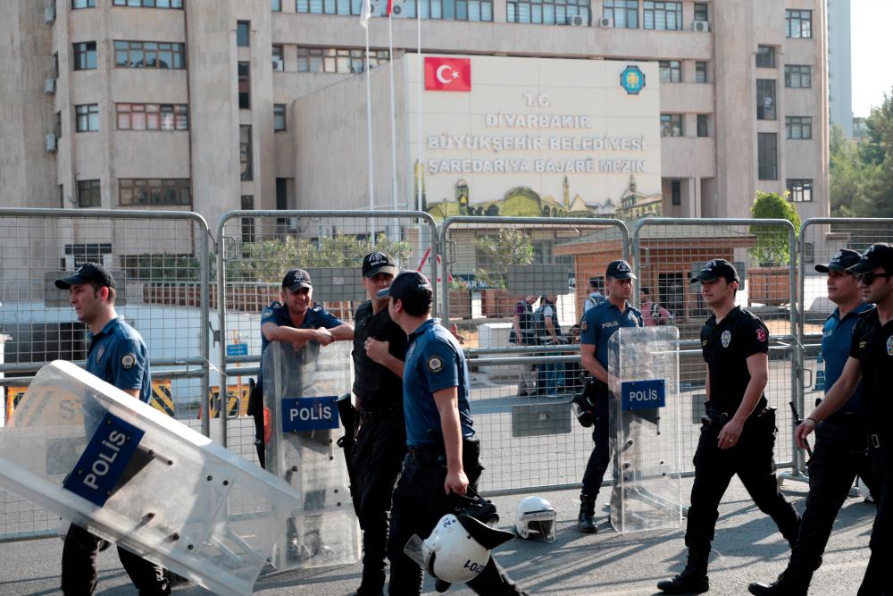 Turkish police walk in front of the Metropolitan Municipality headquarters in Diyarbakir, Turkey, August 19, 2019. — Reuters