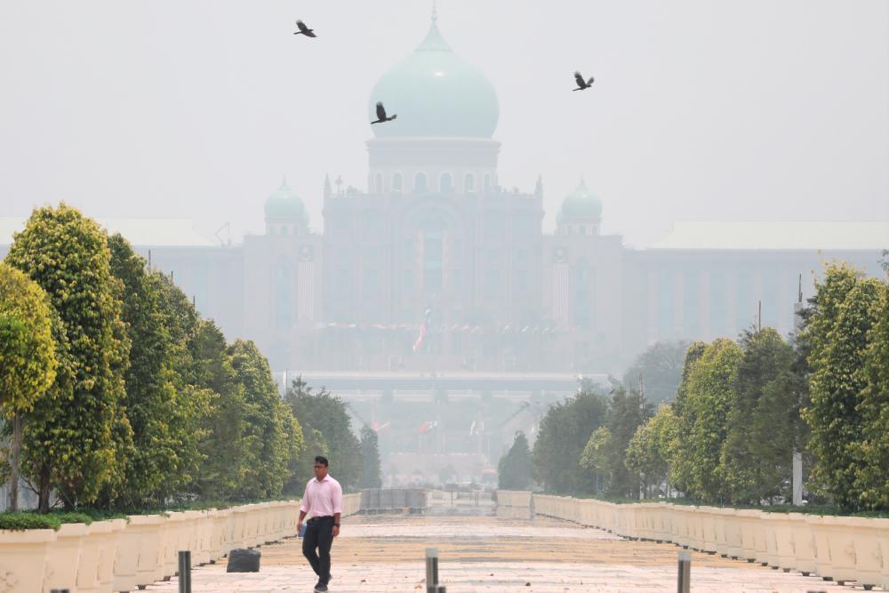 A man passes by Malaysia's Prime Minister's office, which is shrouded in haze, in Putrajaya, Malaysia, Sept 23, 2019. — Reuters