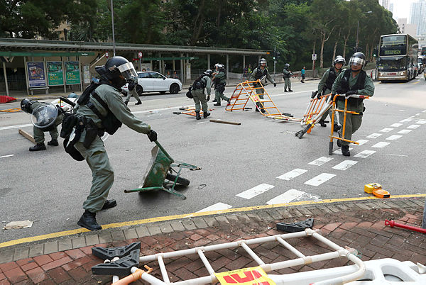 Riot police officers remove barricades set up by anti-government protesters in Wong Tai Sin district in Hong Kong, China, October 13, 2019. — Reuters
