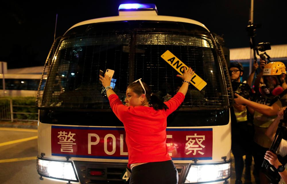 An anti-government demonstrator stands in front of a police vehicle during a protest against the invocation of the emergency laws in Hong Kong, China, Oct 14, 2019. — Reuters