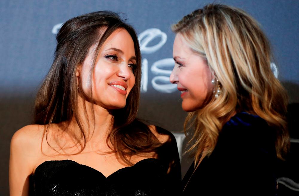 FILE PHOTO: Actors Michelle Pfeiffer and Angelina Jolie look at each other during the European premiere of “Maleficent: Mistress of Evil” in Rome, Italy, October 7, 2019. REUTERS/Yara Nardi/File Photo