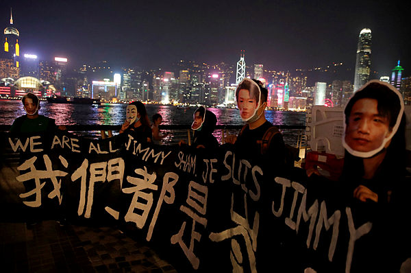 People wearing masks depicting Jimmy Sham hold a banner during an anti-government protest in Hong Kong, China, October 18, 2019. — Reuters