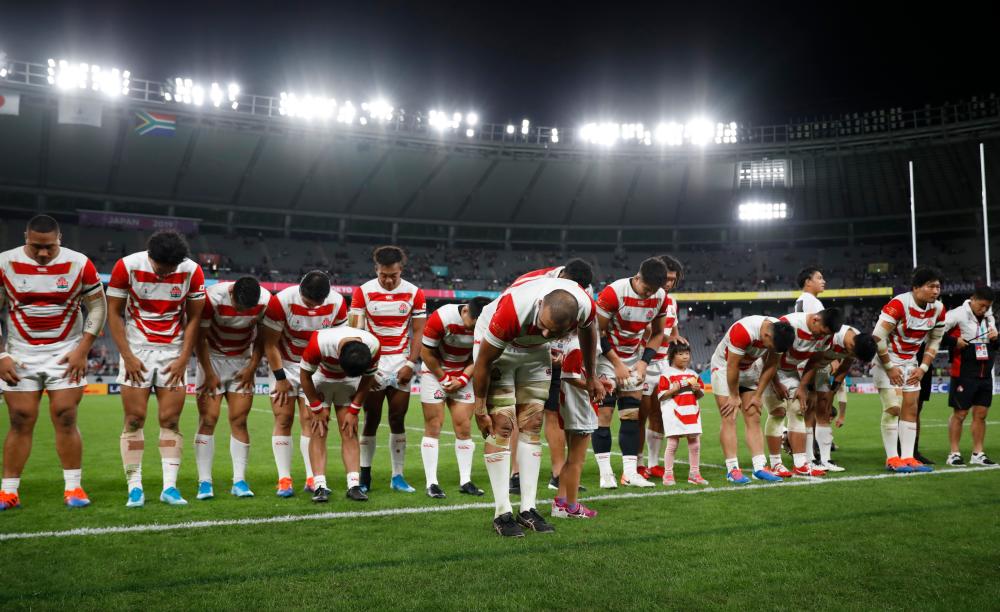 Japan’s players bow to their fans after their match. — Reuters