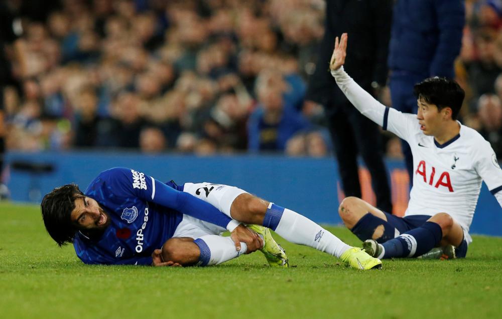 Everton's Andre Gomes reacts after sustaining an injury as Tottenham Hotspur's Son Heung-min gestures during their Premier League match at Goodison Park in Liverpool Nov 3. — Reuters