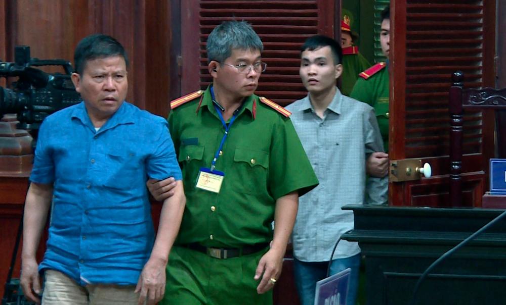 Police escort Chau Van Kham (L) and Tran Van Quyen (R) to their trial at a court in Ho Chi Minh city, Vietnam Nov 11, 2019. — Reuters