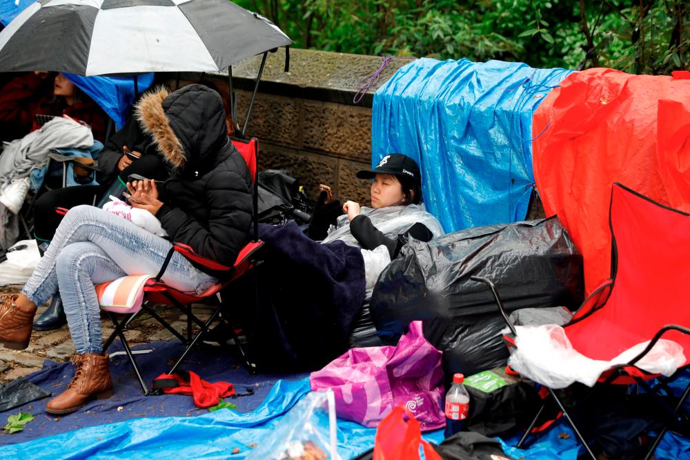File picture of fans of the Korean K-Pop band BTS waiting in the rain outside Central Park in New York a day ahead of a concert performance. New York City, New York, U.S., May 14, 2019. REUTERS/Mike Segar/File Photo