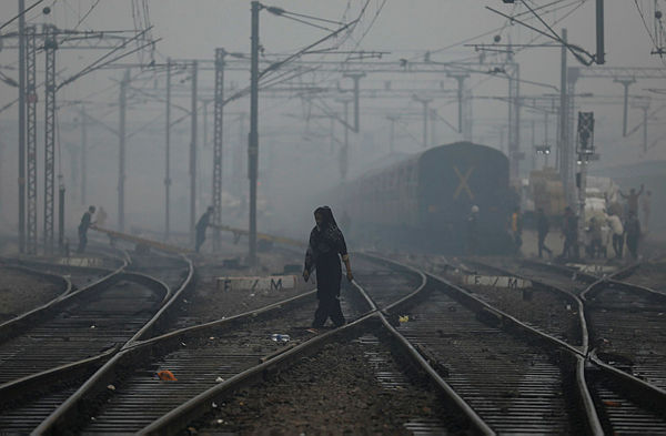 A woman crosses a railway line on a smoggy morning in New Delhi, India, today. — Bernam