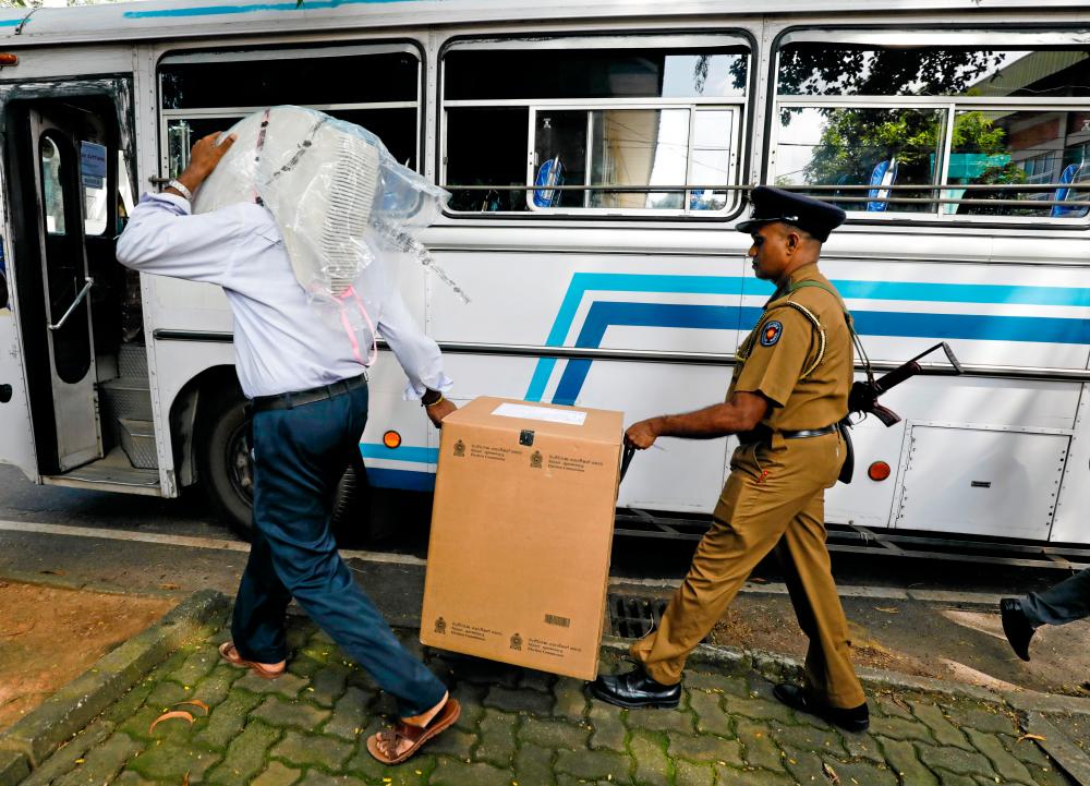 Sri Lankan police and election officials load ballot boxes and papers into busses from a distribution center to polling stations, ahead of country's presidential election scheduled on Nov 16, in Colombo, Sri Lanka. — Reuters