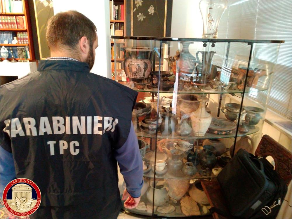 Carabinieri military policeman looks at artefacts in a display case in Cosenza, Italy, Nov 18. — Reuters
