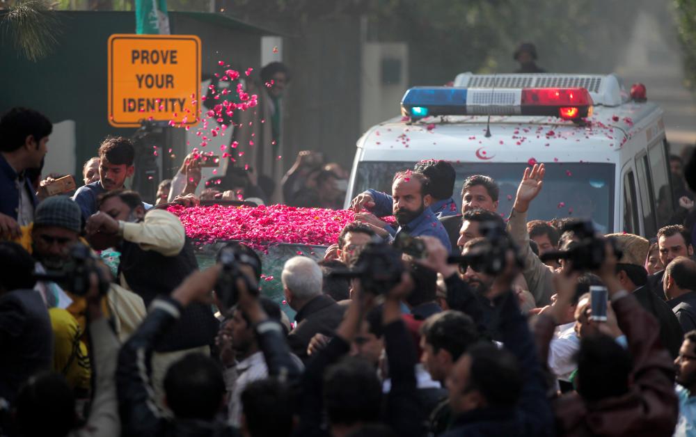 Supporters of Pakistan Muslim League-Nawaz (PML-N) sprinkle rose petals on a car carrying Former Prime Minister Nawaz Sharif, as he makes his way to the airport to travel for a medical treatment in the United Kingdom, outside his residence in Raiwind, near Lahore, Pakistan on Nov 19. — Reuters