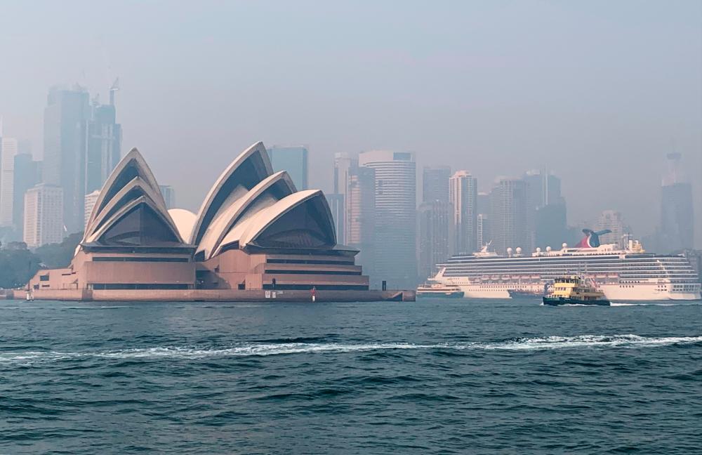 Haze from the ongoing bushfires covers the city skyline and the Sydney Opera House in Sydney, Australia on Nov 21. — Reuters